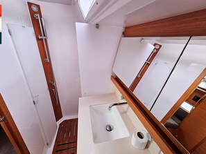 A bathroom with a sink, mirror, and shower.