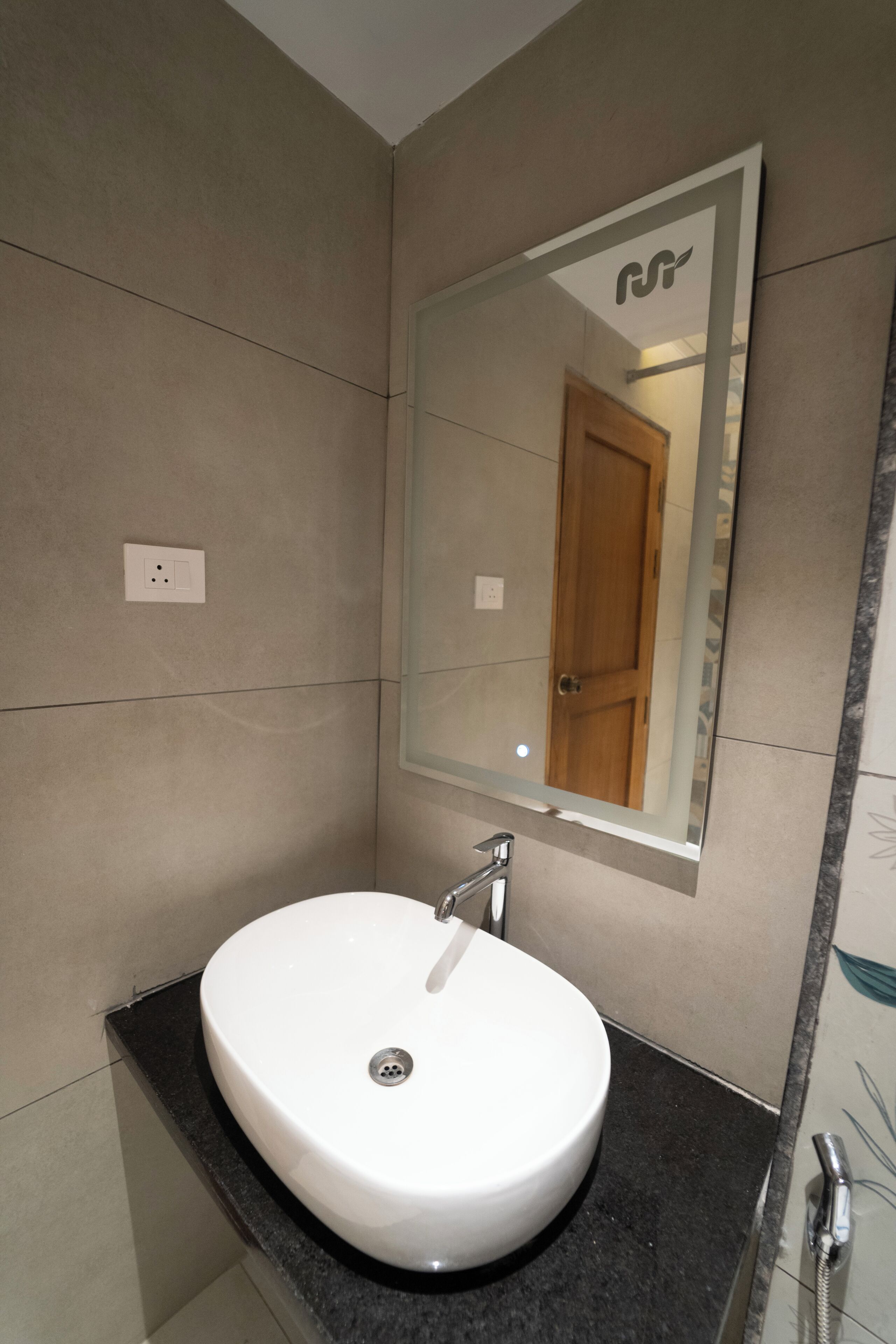 Un baño con un lavamanos blanco, un espejo y una ducha.
