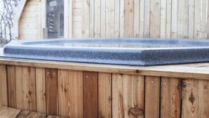 Una terraza de madera con un jacuzzi.
