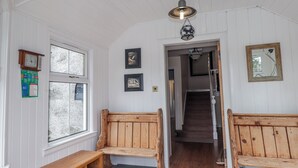 A hallway with wooden benches, a staircase, and a door leading to another room. - Achnagonlin House (Grantown-on-Spey)