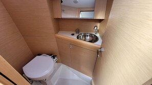 A compact bathroom with a toilet, sink, and cabinet.