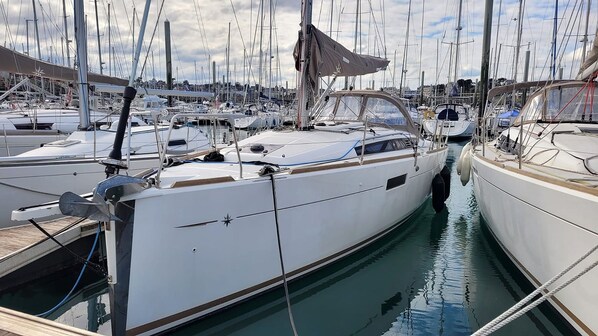 A marina with multiple sailboats docked in calm waters.