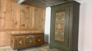 Ett träskåp med blommönster och ett grönt skåp med en dekorativ panel.