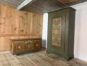 A wooden cabinet with floral designs and a green cabinet with a decorative panel.