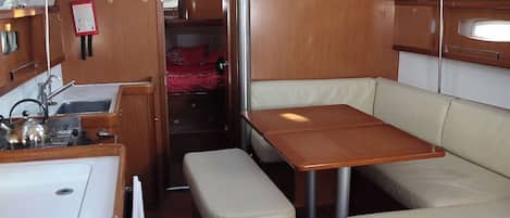 A compact galley with a sink, stove, and storage cabinets.