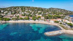 A coastal town with a beach, houses, and a rocky outcrop in the water. - Les Rivages des Issambres by Interhome (Les Issambres)