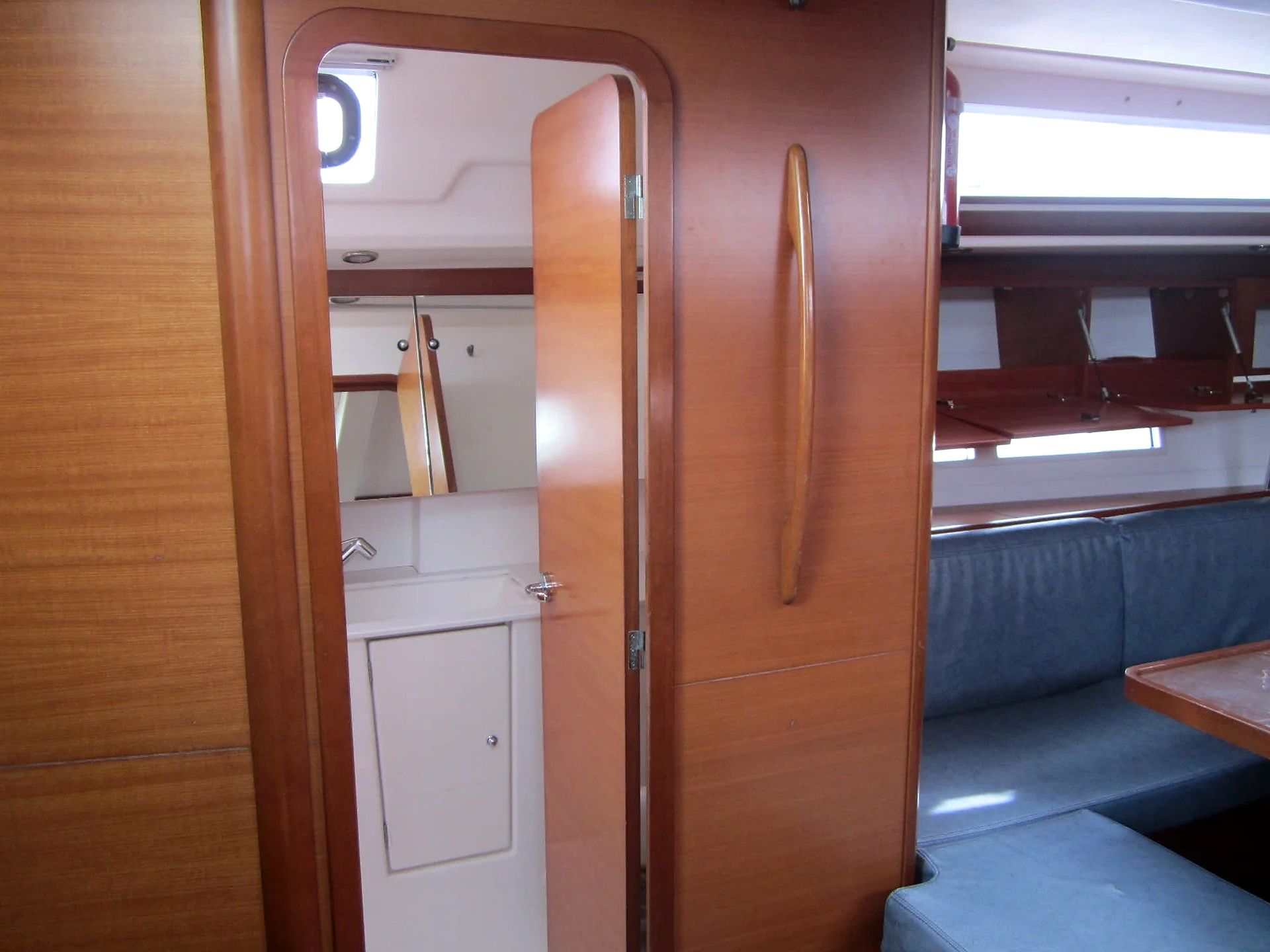 A compact interior with a kitchenette, a small cabinet, and a bench.