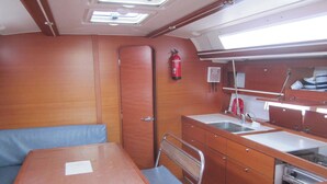 A compact galley with a sink, stove, and a small seating area.