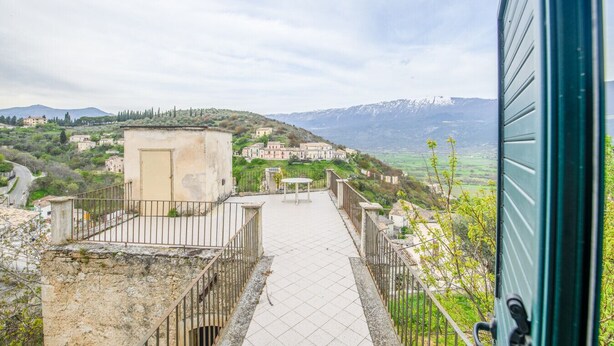A pathway leading to a building with a view of a hillside village and mountains. - Phoebe House - Capestrano (Capestrano)