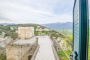 A pathway leading to a building with a view of a hillside village and mountains. - Phoebe House - Capestrano (Capestrano)