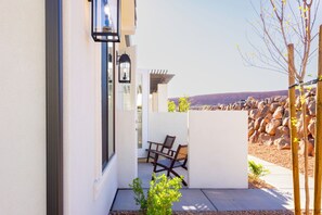 A modern outdoor patio with a view of the landscape, a stone wall, and a wooden fence. - Southern Utah Wonder... Under the Sage Arches. Your family will be close to everything from parks to town when you stay at this centrally-located house. (Washington)
