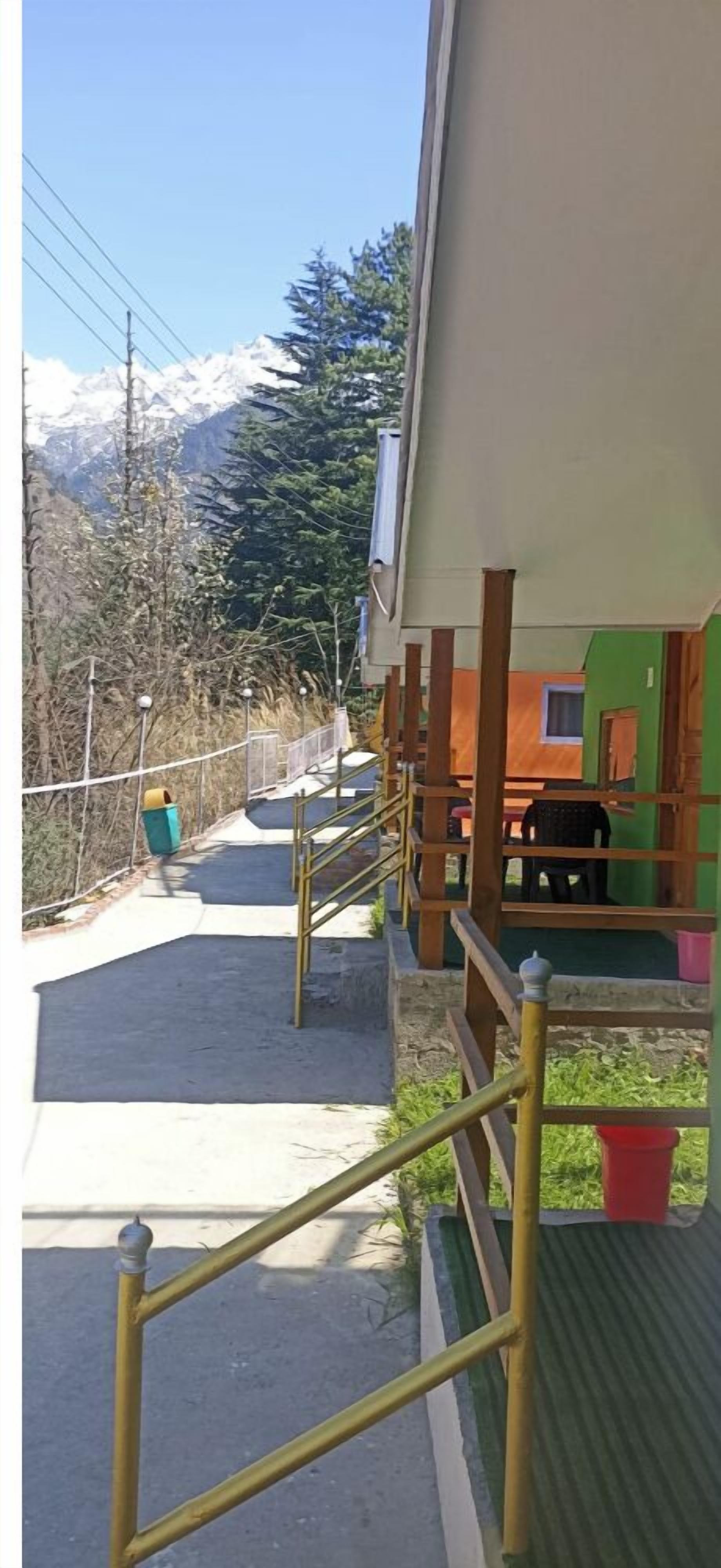 A building with a covered outdoor area, a staircase, and a view of snow-capped mountains.