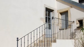 Un escalier avec une rampe métallique menant à une porte.