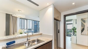 Een moderne keuken met een dubbele spoelbak, roestvrijstalen apparatuur en een groot raam met uitzicht over de stad.