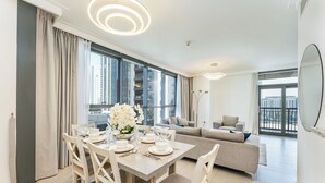Een moderne woonkamer met een eetgedeelte, grote ramen en stadszicht.