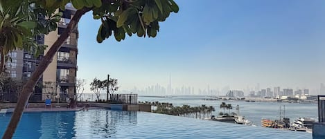 Piscina com vista para o horizonte urbano e água.
