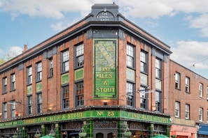 Ein Eckgebäude mit einem Schild, auf dem 'Courages Fine Ales & Stout' und 'The Exmouth Arms' über dem Eingang zu sehen sind.