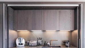 A modern kitchen with built-in cabinets, a countertop, a coffee machine, a toaster, and a sink.