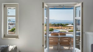 A room with a view of a pool and outdoor seating, a window, and a door leading outside. - Seaside Paros Ambelas Villa 1 (Paros)
