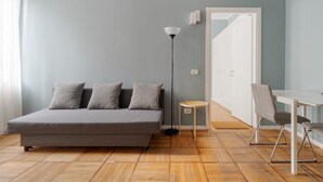 Una habitación con cama, escritorio, silla, lámpara y puerta.