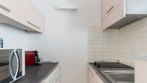 Una cocina equipada con lavadora, cafetera y microondas.