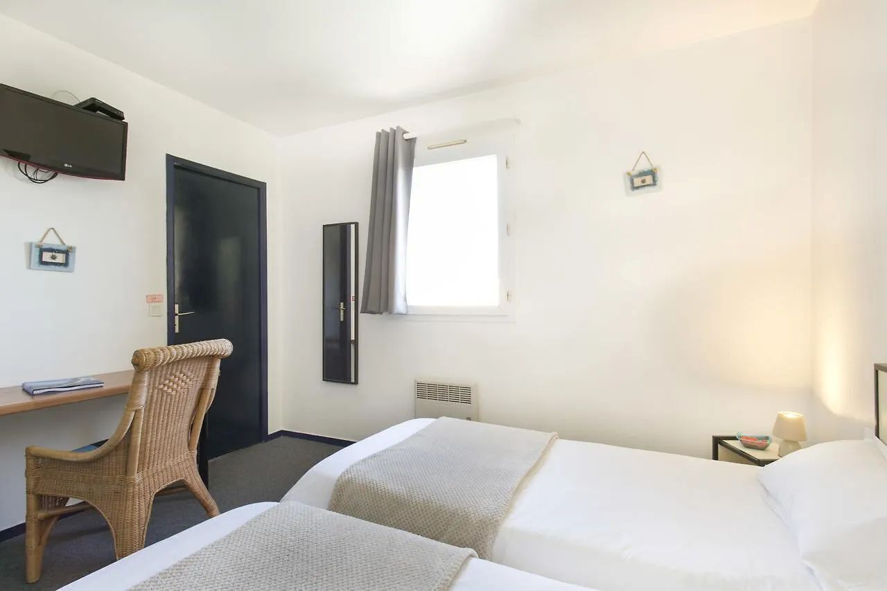 A hotel room with two beds, a desk, a chair, a television, a window with curtains, and a small wall decoration.