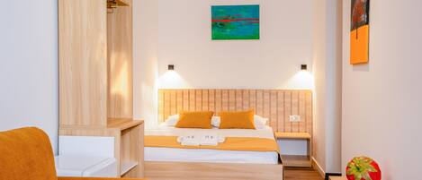 Una habitación de hotel con cama, mesitas de noche, sofá y obras de arte en las paredes.