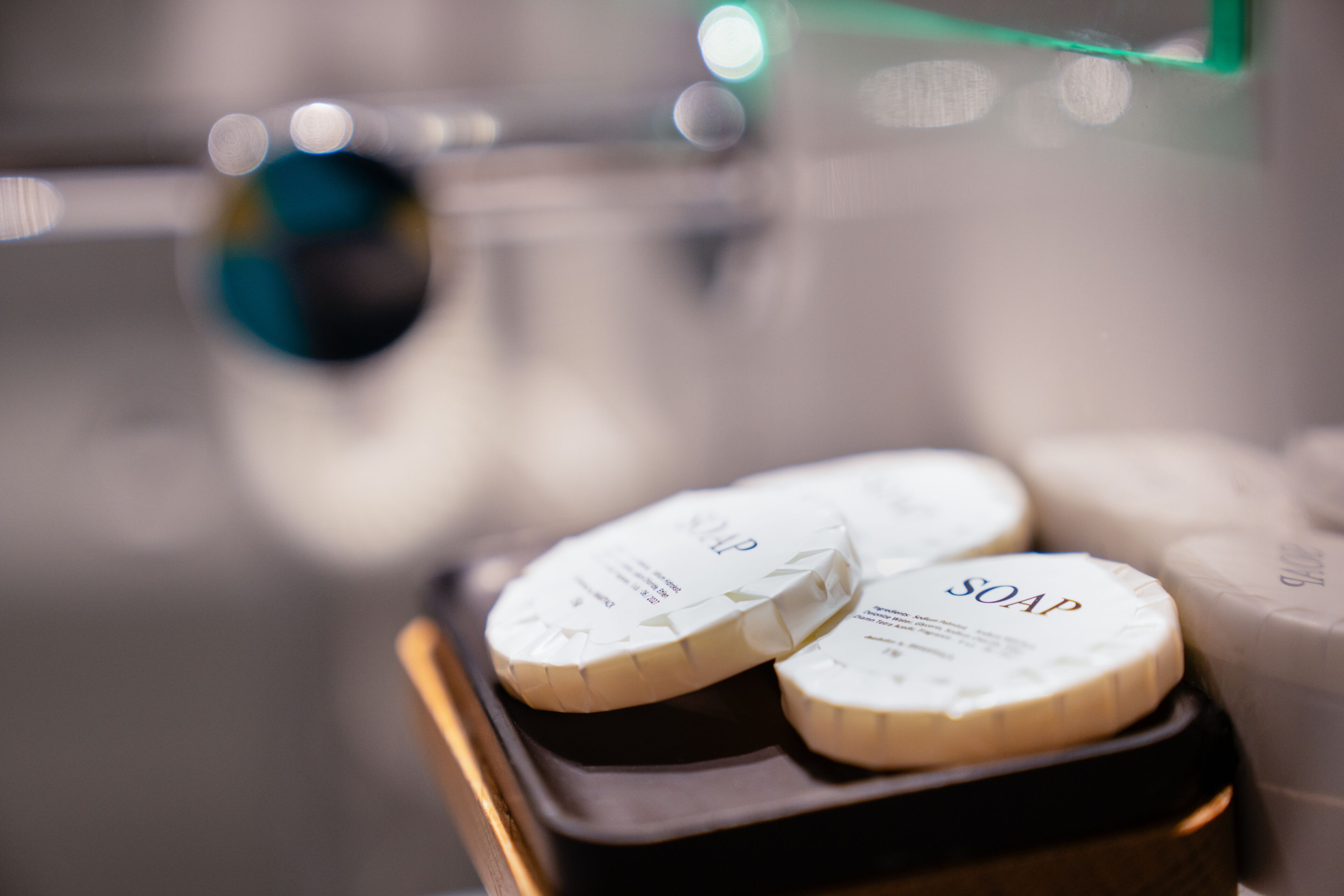 A tray with soap bars and a container, likely in a hotel setting.