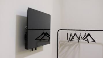 A wall-mounted black cabinet and a white fabric hanging on a black metal rack.