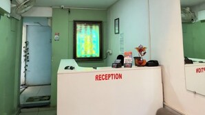 Ett entréområde med en receptionsdisk märkt med texten ”RECEPTION”, ett fönster med utsikt och ett tak med infälld belysning.