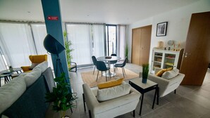 Un salon moderne comprenant un canapé, des fauteuils, une table à manger et un meuble.