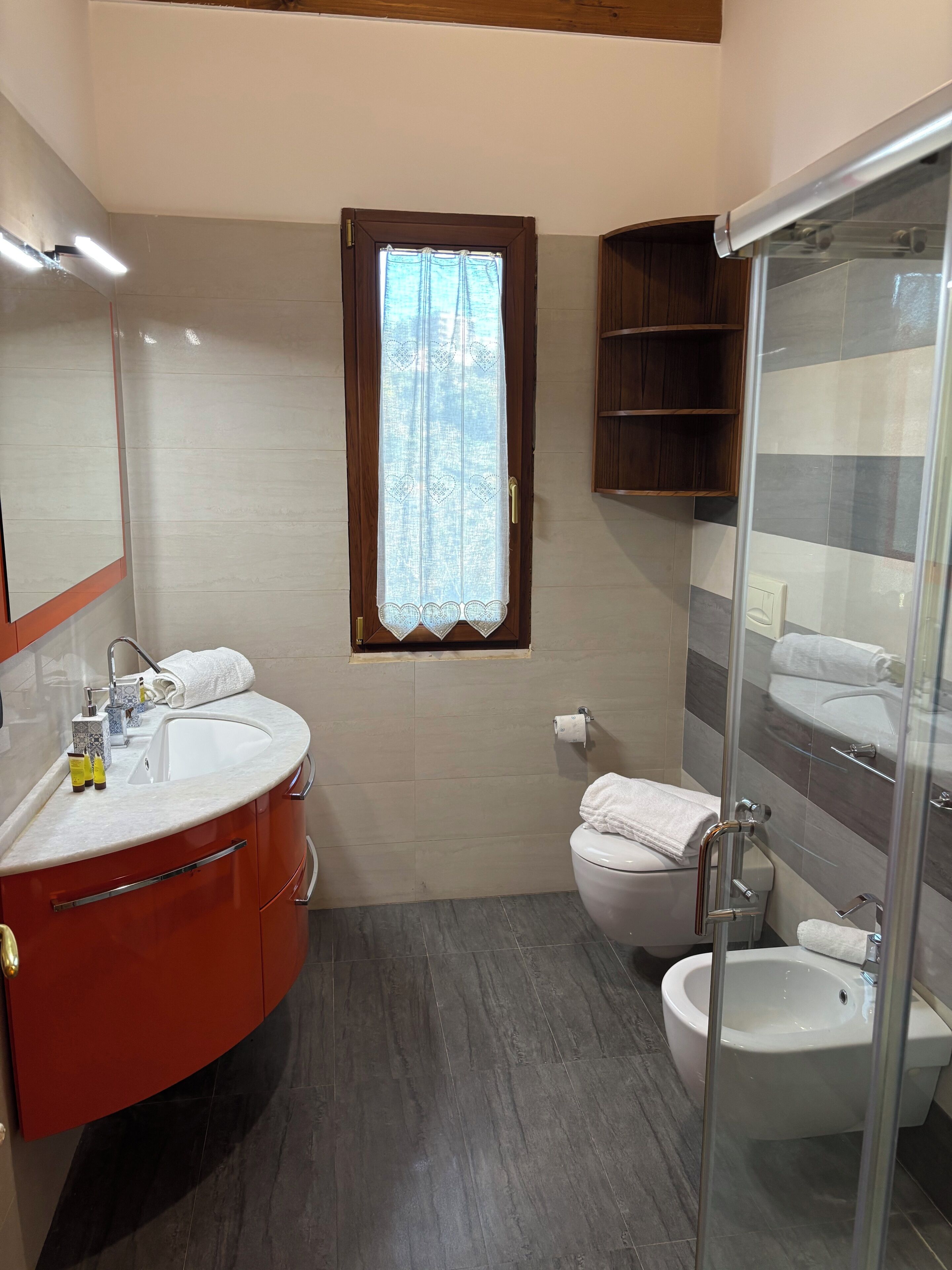 Ein Badezimmer mit Waschtisch, Spüle, Toilette, Bidet und Duschbereich.