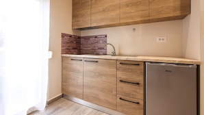Eine Küche mit Holzausstattung, einer Stein-Spritzschutzwand und einem eingebauten Geschirrspüler.