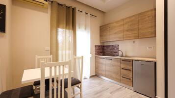 Una cocina moderna con armarios de madera, un salpicadero de ladrillo integrado y un lavavajillas compacto.