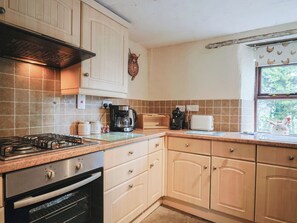 A kitchen with a gas stove, oven, coffee maker, toaster, and cabinets. - Cider Cottage - Near Lyme Regis (Axminster)
