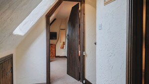 A hallway with a wooden door, a light fixture, and a framed picture on the wall. - Cider Cottage - Near Lyme Regis (Axminster)