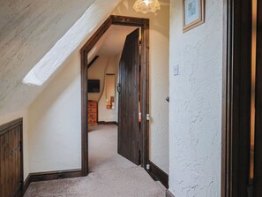 A hallway with a wooden door, a light fixture, and a framed picture on the wall. - Cider Cottage - Near Lyme Regis (Axminster)
