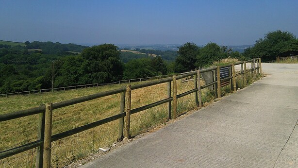 A paved pathway alongside a wooden fence with a view of a green landscape and distant hills. - Cider Cottage - Near Lyme Regis (Axminster)