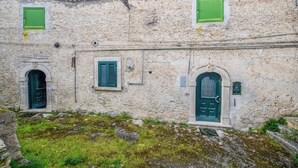 A building with two arched doorways and two windows with shutters. - Casa Phoebe (Capestrano)