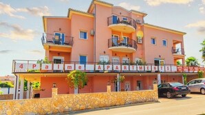 Um edifício com várias andares e varandas, com a placa '4 Palma Apartments'.