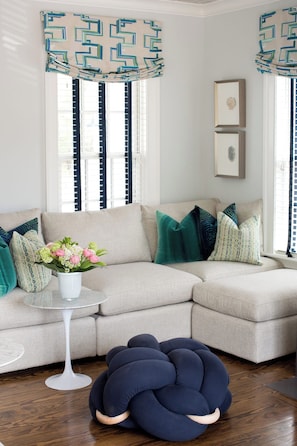 A modern living room with a sectional sofa, decorative pillows, a round coffee table, and a unique blue pouf. - Marion HOUSE - Village, Large Deck, Close to Tabor (Marion)