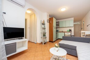 A compact living space with a TV, sofa, and small dining area. - Modern apartment just 300 m from the sea in Selce with balcony and private parking space (Selce)