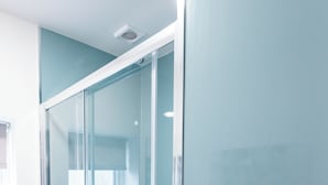 A bathroom with a glass shower enclosure, a toilet, and a sink. - Glan Neigr by Guestz (Rhosneigr)