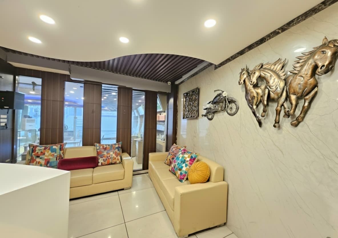 Uma sala de estar moderna com dois sofás, uma motocicleta pendurada na parede e uma parede decorada com esculturas de cavalos.
