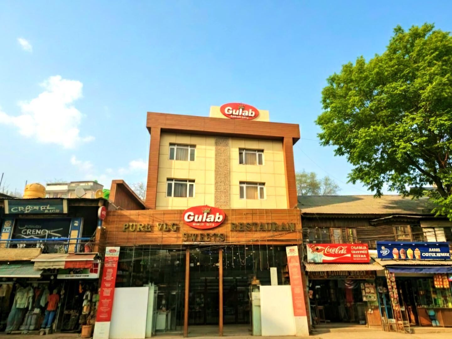 A building with a sign reading 'Gulab Restaurant' and a Coca-Cola sign on the right.