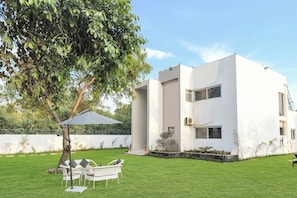 A modern two-story building with a white exterior, a small front porch, and a well-maintained lawn.