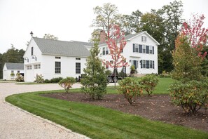 A white two-story house with a front lawn and a gravel driveway. - New Marion renovated, bright, cozy home! (Marion)