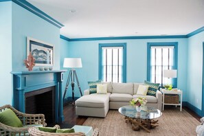 A living room with a blue wall, a fireplace, a sofa, a coffee table, and a lamp. - New Marion renovated, bright, cozy home! (Marion)