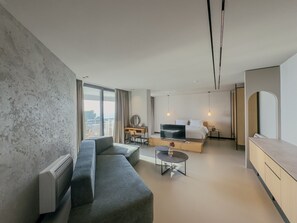 A modern living room with a sofa, a TV, a coffee table, and a desk. - Zins Luxury Rooms (Durrës)