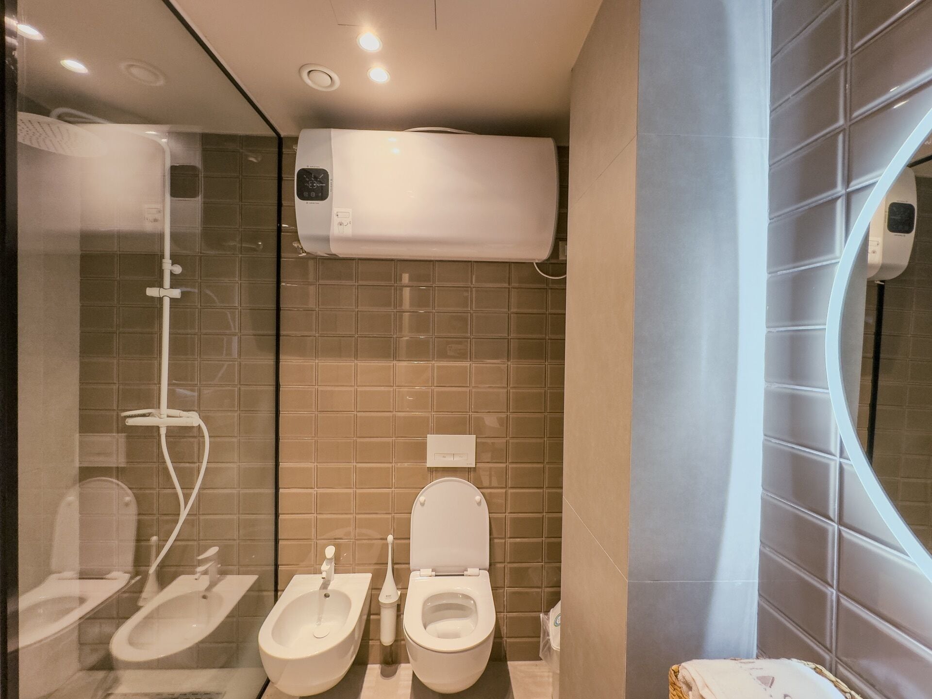 A modern bathroom with a shower, bidet, and toilet.
